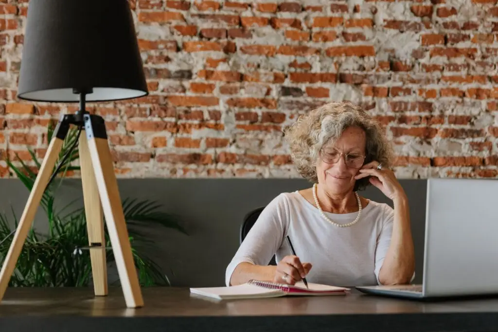 Woman in her sixties working at a laptop, planning flexible income in retirement