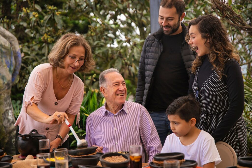 Three generations laughing together over a family meal outdoors